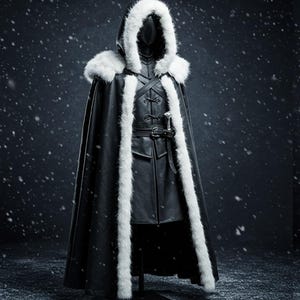 May include: A black hooded cloak with a white fur trim. The cloak is long and flowing, and the hood is pulled up over the head. The cloak is worn over a black leather outfit with a belt and a sword.