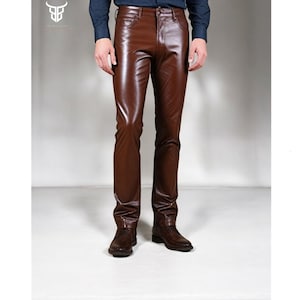 May include: Brown leather pants with a slim fit. The pants have a zipper fly and belt loops.
