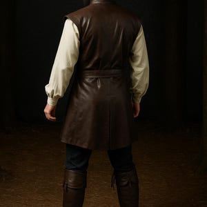 May include: A brown leather pirate costume, including a tricorn hat, vest, and knee-high boots. The vest has a belt and is worn over a cream-colored shirt. The boots and hat are a darker shade of brown.