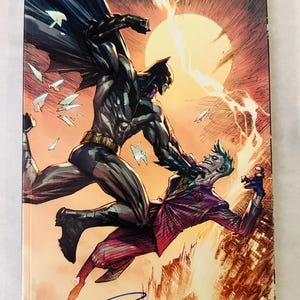 May include: Comic book cover featuring Batman in a dynamic fight scene with the Joker. The artwork is set against a fiery orange and yellow background with the text "Detective Comics #1027" and the DC logo.