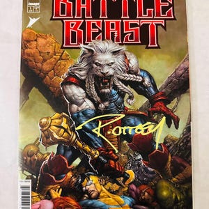 以下が含まれることがあります： 「Invincible Universe: Battle Beast」のコミックカバー。白い鬣の戦士と金のメイスが描かれています。タイトルは赤と白。カバーは黄色でサインされています。Image Comicsから出版。