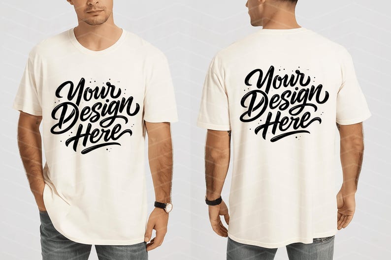 May include: Cream-colored t-shirt with the text "Your Design Here" in a black, stylized script on the front and back. The shirt is short-sleeved and has a relaxed fit. The model is wearing blue jeans and a watch.