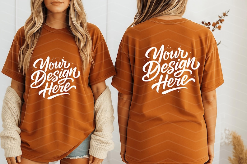 May include: Rust-colored t-shirts with the text "Your Design Here" in white script. The shirts have a relaxed fit and are displayed on a person. The back of the shirt also features the same text. The shirts are a blank canvas for custom designs.