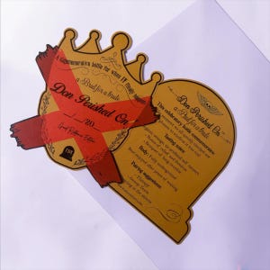 May include: A gold-colored, die-cut card shaped like a crown and a tombstone. The crown section features a red X and the text Don Perished On. The tombstone section includes the text Don Perished On, a skull icon, and detailed tasting notes.