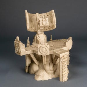 Könnte beinhalten: Ein beiges, detailliertes Miniatur-Wargaming-Geländestück. Die Struktur weist einen zentralen Turm mit gewölbtem Oberteil, eine Plattform und ein Totenkopfemblem auf. Die Basis ist eine felsige Formation. Das Logo "Wargame Wonders" ist sichtbar.