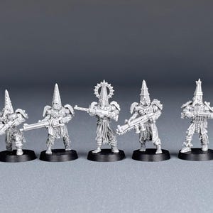 May include: Five unpainted plastic miniatures of figures wearing hooded robes and holding rifles. The figures are standing on circular bases.