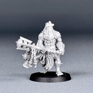 May include: A gray plastic miniature figure of a warrior holding a spiked mace with a chain. The figure is wearing a hooded cloak and armor. The figure is standing on a black base.