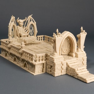 Può includere: Una miniatura dettagliata di un edificio in stile gotico, stampato in 3D in beige, con una figura di demone seduta su un trono. L'edificio ha un grande portale ad arco e un balcone con dettagli intricati.
