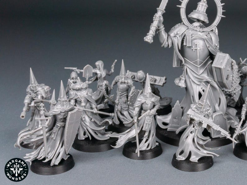 May include: A collection of unpainted miniature figures, likely for tabletop gaming. The figures are primarily gray, featuring detailed armor, flowing robes, and various weapons. Some figures have tall, pointed hats. The figures are on black bases.