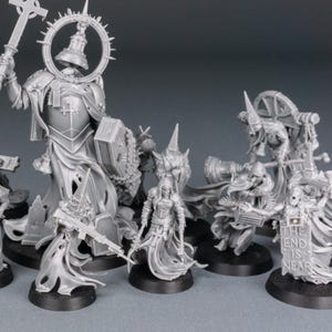 May include: A collection of unpainted miniature figures, likely for tabletop gaming. The figures are primarily gray and feature detailed armor, weapons, and religious iconography. One figure holds a sign that reads "THE END IS NEAR."