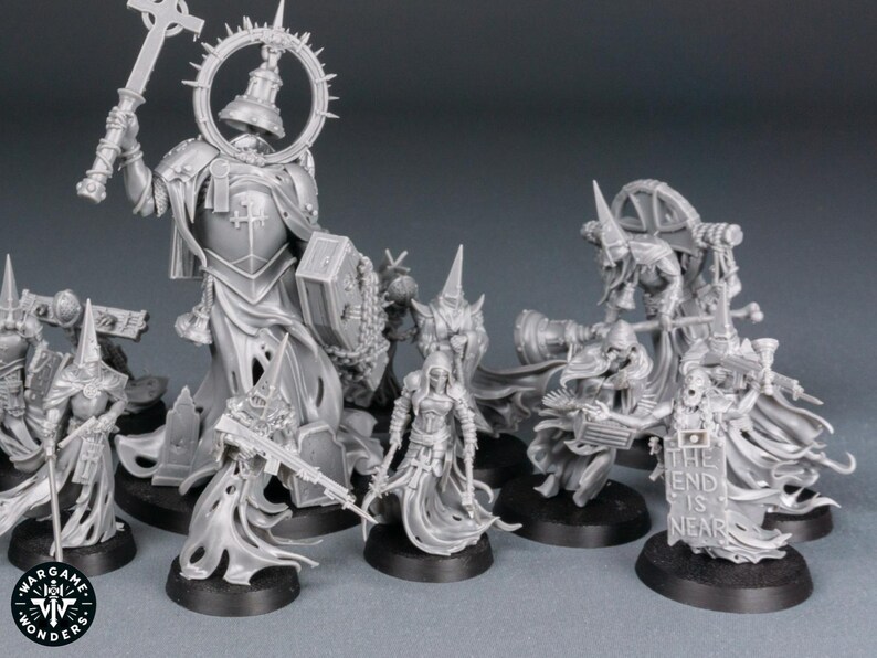 May include: A collection of unpainted miniature figures, likely for tabletop gaming. The figures are primarily gray and feature detailed armor, weapons, and religious iconography. One figure holds a sign that reads "THE END IS NEAR."