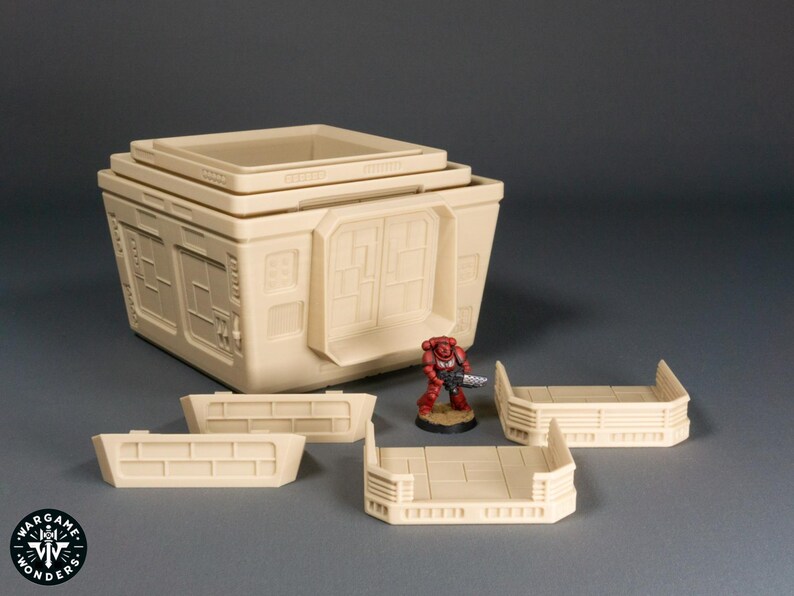 May include: A set of modular, beige plastic building pieces for tabletop gaming. The pieces include a multi-level building with windows and a flat roof, and three separate wall sections.