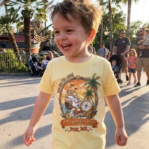 Pu&ograve; includere: Una maglietta gialla con una grafica a tema pirata. La grafica presenta un coniglio dei cartoni animati, una nave pirata, una bussola e la scritta "A Pirate's Life For Me". La maglietta ha anche la frase "Yo Ho Yo Ho".