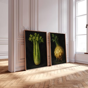 May include: Two framed botanical art prints featuring celery and celeriac against a black background. The celery print shows a green and white stalk with leafy tops. The celeriac print displays a round, yellow-brown root vegetable with green leaves.