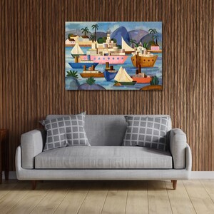 May include: Colorful abstract painting of a harbor scene with boats, buildings, and palm trees. The artwork features a variety of boats in blue, pink, and brown hues, set against a blue sky and water. The painting is displayed above a gray sofa.