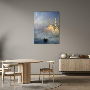 May include: A rectangular wall art print featuring an oil painting of a mosque with two tall minarets illuminated by golden light, situated on a misty waterfront with a small boat floating on the dark blue water in the foreground.