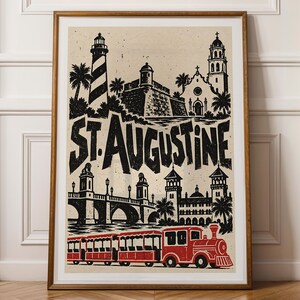 Peut inclure: Une impression encadrée présentant une illustration en noir et blanc des monuments de St. Augustine, incluant un phare, un fort et un pont, avec le texte ST. AUGUSTINE en grandes lettres et un train touristique rouge en bas.