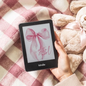 May include: A pink watercolor bow with the text "i'm just a girl" on a Kindle e-reader.