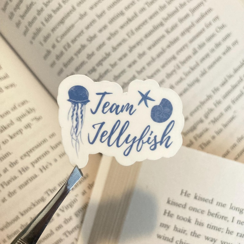 May include: A white sticker with blue text and a blue jellyfish illustration. The text reads "Team Jellyfish" with a blue starfish above the word "Team".