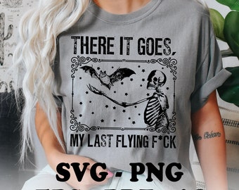 May include: A grey t-shirt with a black graphic of a skeleton holding a bat with the text "THERE IT GOES. MY LAST FLYING F*CK" and the words "SVG.PNG EPS-PDF-AI" below the graphic.