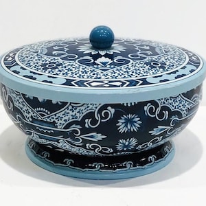 May include: A blue and white porcelain bowl with a lid. The bowl has a floral design and the lid has a blue knob.