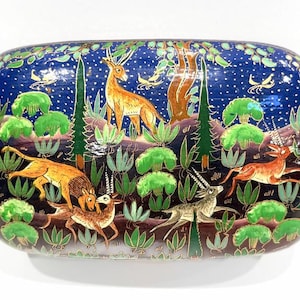 May include: Rectangular decorative box with a forest scene. The box features a dark blue background with a starry night sky. The forest scene includes deer, lions, and trees in shades of brown, green, and orange.