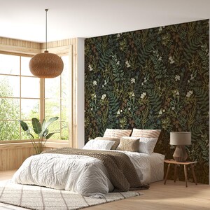 May include: A white bed with a brown blanket and pillows in a bedroom with a large window and a floral patterned wallpaper.