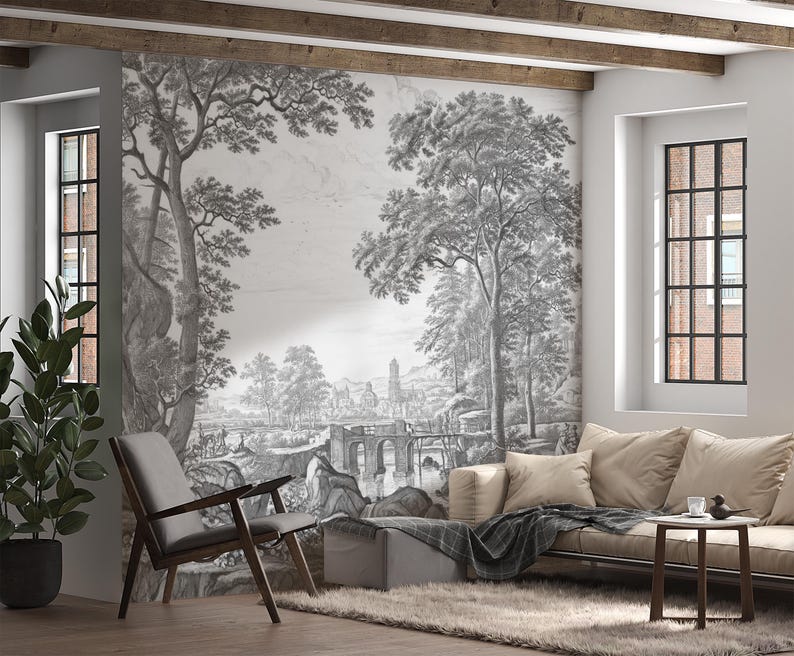 May include: A black and white photo print of a landscape scene with trees, a bridge, and a building in the distance. The print is framed and hanging on a wall in a living room.