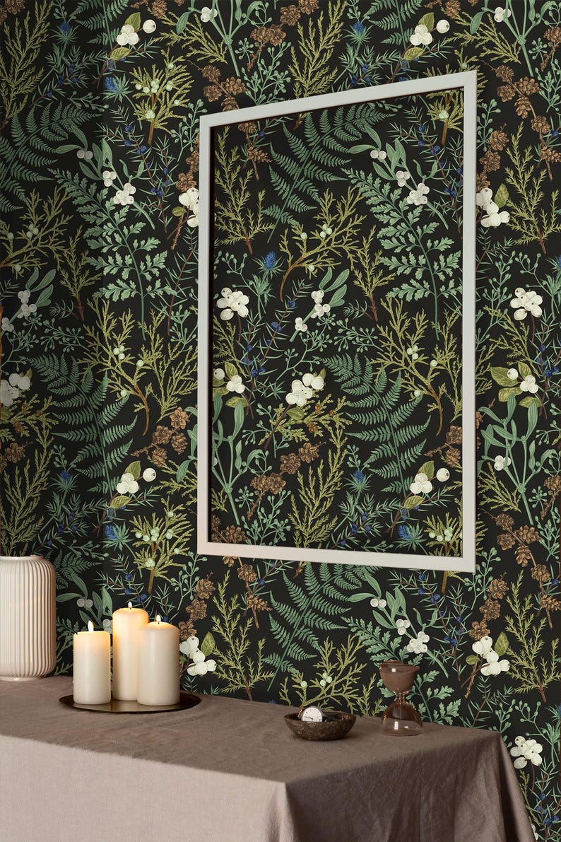 May include: A black and green wallpaper with a botanical pattern featuring ferns, leaves, and white flowers. The wallpaper is framed by a white picture frame and displayed on a wall in a room with a table and candles.