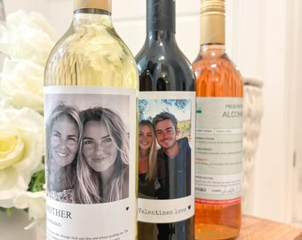 Puede incluir: Tres botellas de vino con etiquetas personalizadas. Una botella está etiquetada como "Mother" con una foto de dos mujeres, otra dice "Valentines love" con una foto de una pareja, y la tercera tiene una etiqueta con texto. Las botellas tienen tapones dorados y negros.