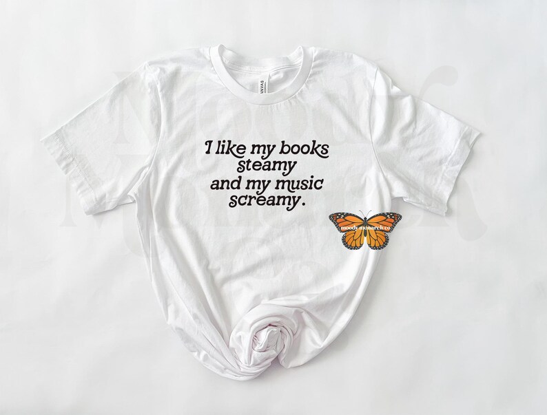 May include: White t-shirt with the text "I like my books steamy and my music screamy."