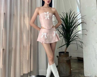 A set of pink crop-top and mini skirt with ribbons