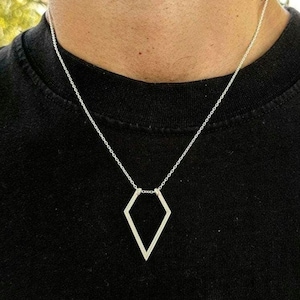 May include: A silver chain necklace with a geometric diamond-shaped pendant.