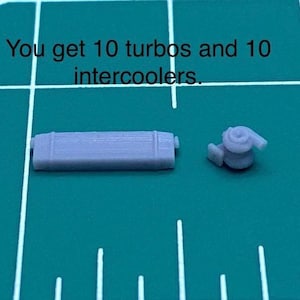 May include: Two small, grey automotive parts are on a green grid. The text above reads, "You get 10 turbos and 10 intercoolers." One part is rectangular, the other is a turbocharger. The parts are likely for a model car or similar project.