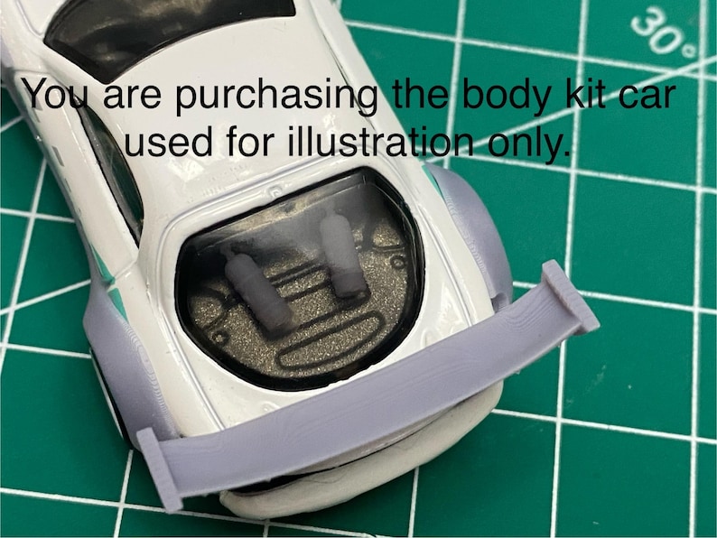 K&ouml;nnte beinhalten: Ein wei&szlig;er Karosserie-Kit f&uuml;r ein Auto mit einem Heckspoiler. Der Kit besteht aus glattem, hellgrauem Kunststoff. Der Text "You are purchasing the body kit car used for illustration only." ist im Bild sichtbar.