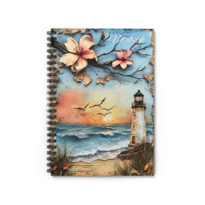 May include: A spiral bound notebook with a colorful cover featuring a lighthouse on a beach with a sunset in the background. The cover also has a floral design with pink flowers and a distressed look.