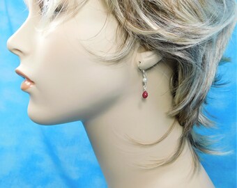 May include: Silver dangle earrings with a red gemstone and two white pearls.