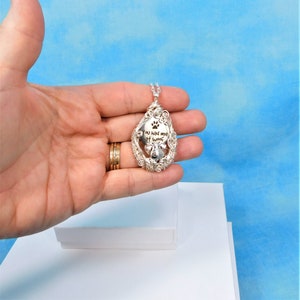 May include: Silver pendant necklace with a paw print and the text "You had me at woof".