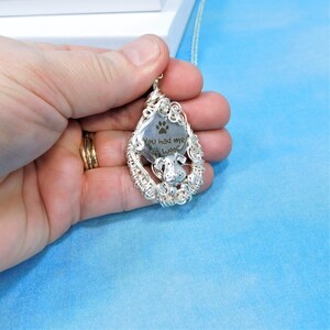 May include: Silver pendant necklace with a teardrop-shaped charm featuring a dog silhouette and the engraved text "You had me at woof".
