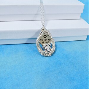 May include: Silver necklace with a wire-wrapped pendant featuring a paw print and the text "You had me at woof".
