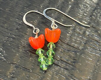 Orangey red flower Czech Glass Drop Earrings, green Swarovski Crystals stems. Silver wire.