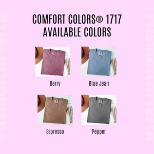 May include: A color chart for Comfort Colors 1717 t-shirts displaying four folded shirts in berry, blue jean, espresso, and pepper colors. Each shirt is shown next to a brown hat and dried foliage. The text reads Comfort Colors 1717 Available Colors.