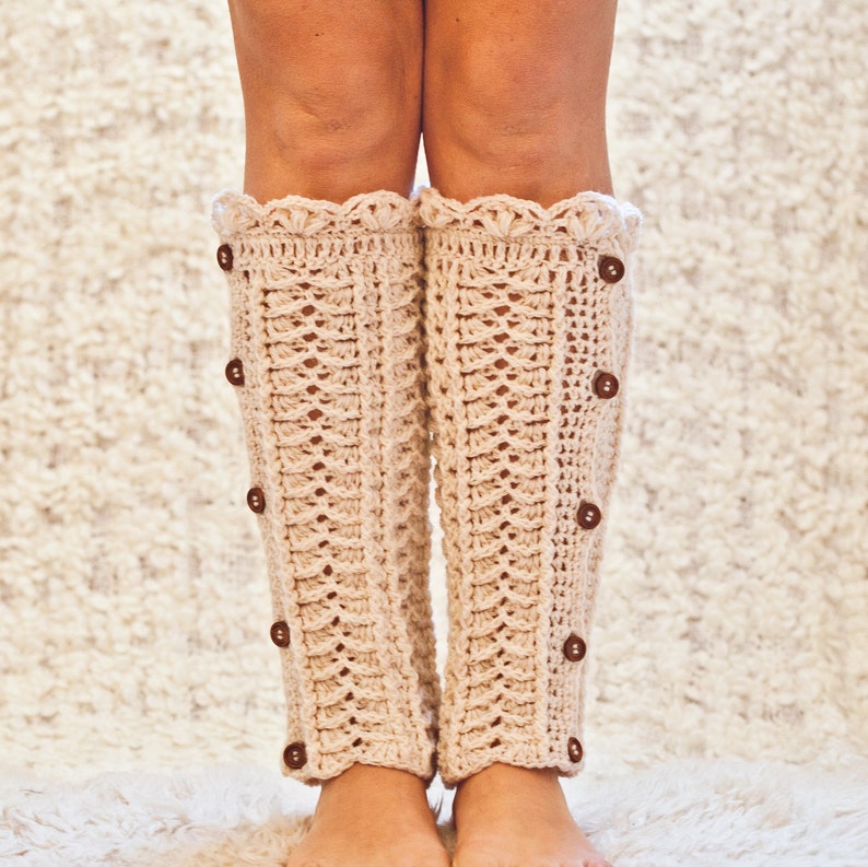 May include: A pair of beige crocheted leg warmers with a scalloped edge and brown buttons.