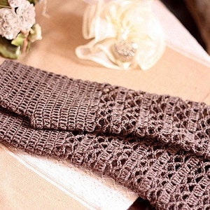 May include: A pair of brown crocheted fingerless gloves with a lacy pattern.