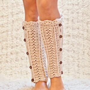 May include: A pair of cream-colored crocheted leg warmers with a scalloped top and brown buttons down the side.