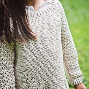 K&ouml;nnte beinhalten: Ein hellbeige H&auml;kelpullover mit langen &Auml;rmeln. Der Pullover hat einen runden Ausschnitt und ein strukturiertes, offen gewebtes Design. Die &Auml;rmel haben ein offeneres, spitzenartiges Muster. Der Pullover ist aus weichem, nat&uuml;rlich aussehendem Garn gefertigt.