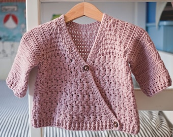 Op de afbeelding: Een roze gebreid vest met knoopsluiting. Het vest heeft een V-hals en is gemaakt met een textuur.