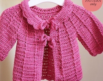 May include: A pink crocheted baby cardigan with a scalloped collar and a bow detail at the front. The cardigan is on a white hanger. The text "pdf PATTERN only" is in a circle in the upper right corner of the image.