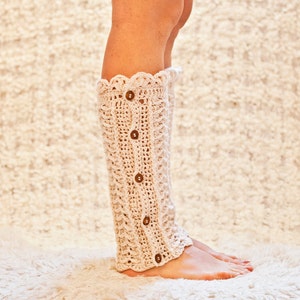 May include: A pair of cream-colored crocheted leg warmers with a scalloped top and button closures.