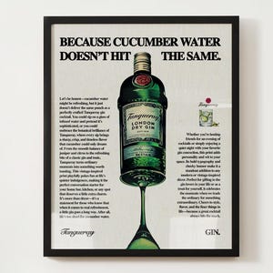 Könnte beinhalten: Eine Vintage-Werbung für Tanqueray London Dry Gin. Die Anzeige zeigt eine Flasche Gin mit einem grünen Etikett und ein Glas Gin mit einer Gurkenscheibe. Der Text lautet "Denn Gurkenwasser trifft nicht auf die gleiche Weise".